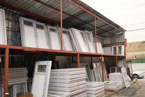 Kapalı depoda raflara dizilmiş PVC kapı ve pencereler
